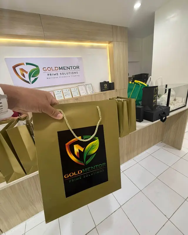 A Goldmentor Prime Solutions shopping bag being handed over at the counter